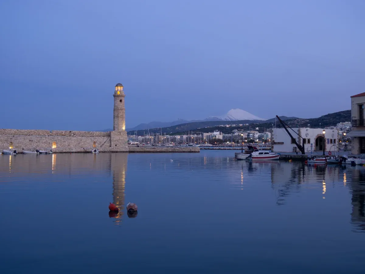 The Venetian lighthouse and old harbour of Rethymno at dusk, Crete, one of the two islands in the crete or santorini decision