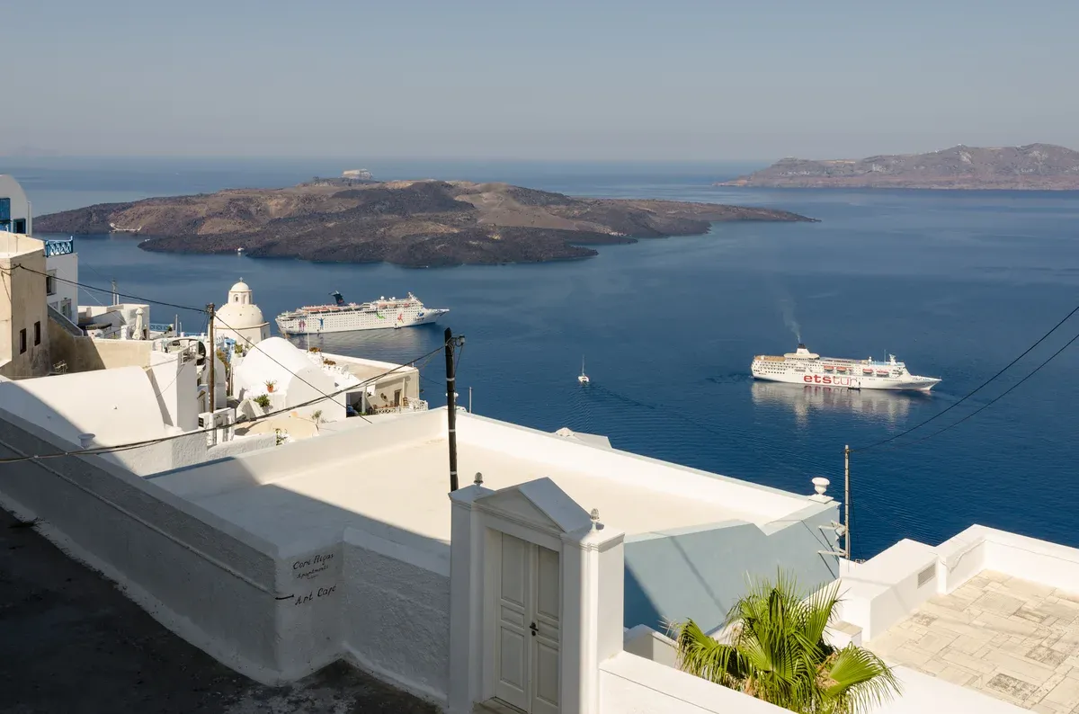 Fira on the caldera rim of Santorini with Nea Kameni behind, the other island in the crete or santorini decision